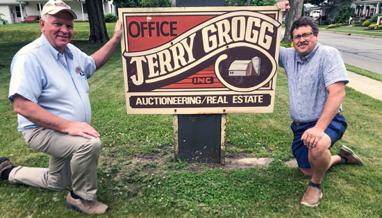 Jeff Burlingame & Steve McKowen kneeling next to the Jerry Grogg office sign
